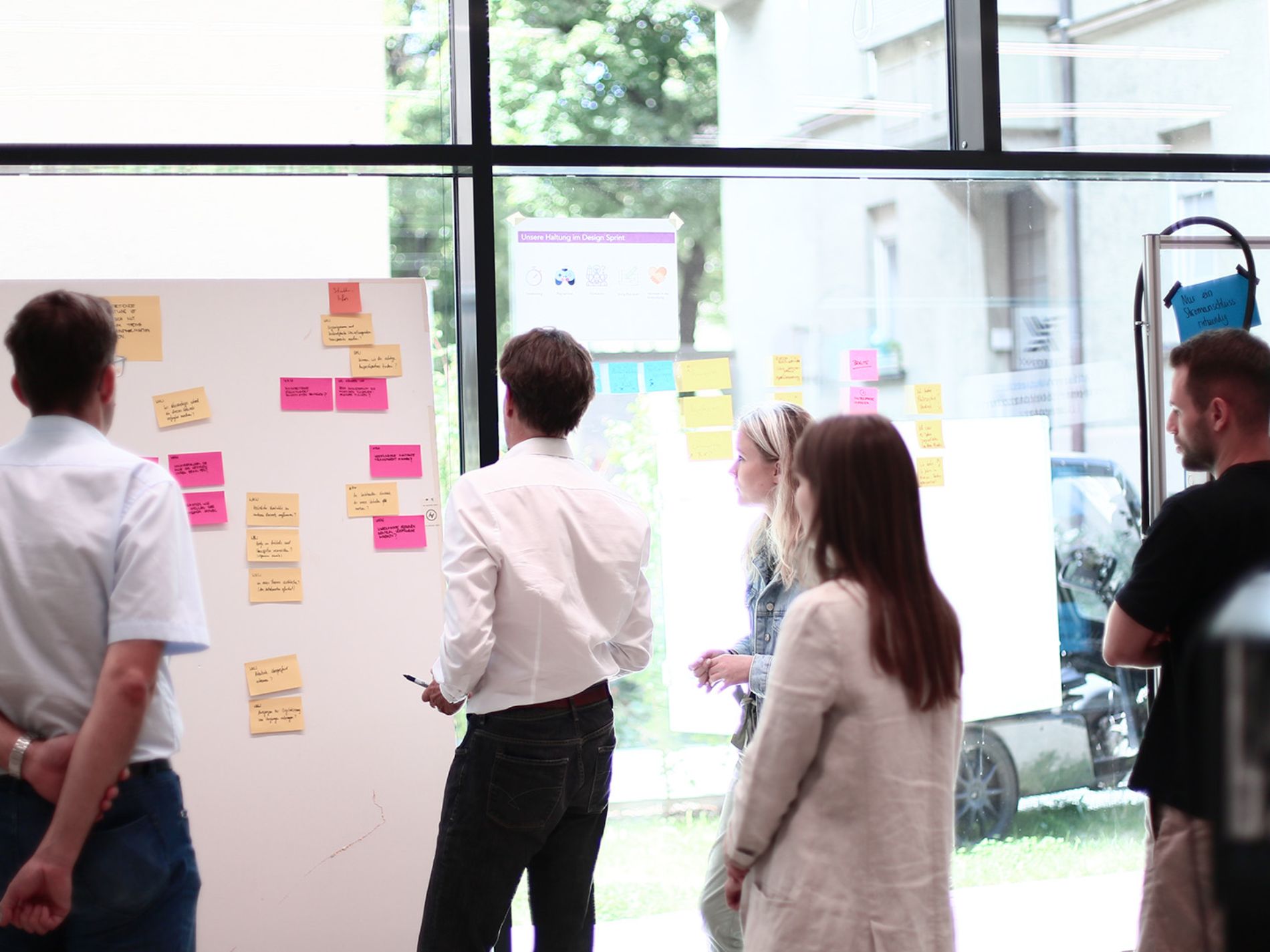 Gruppe steht vor Pinnwand